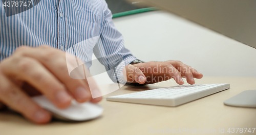 Image of hands typing on computer keyboard in startup office