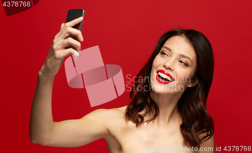 Image of beautiful woman taking selfie with smartphone