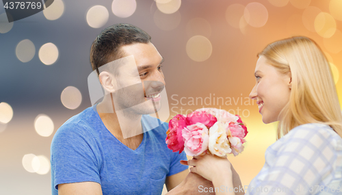 Image of happy couple with flowers over lights background