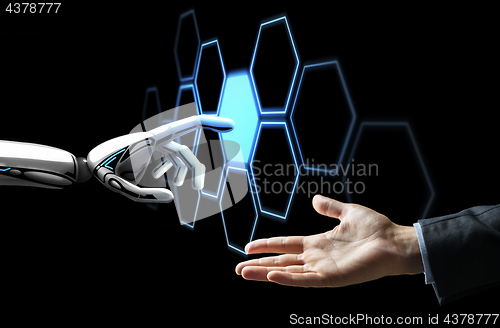 Image of human hand and robot touching network hologram