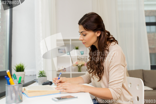 Image of female student with book learning at home