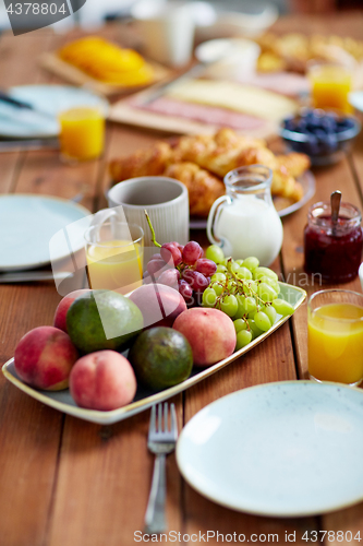 Image of fruits, juice and other food on table at breakfast