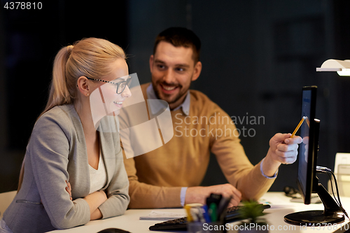 Image of business team with computer working late at office
