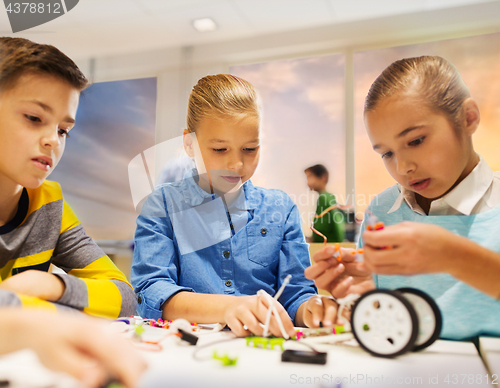 Image of happy children building robots at robotics school