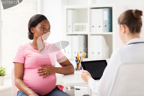 Image of doctor with tablet pc and pregnant woman at clinic