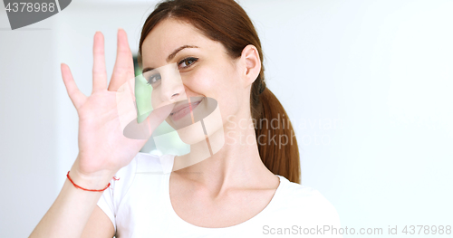 Image of woman sending kiss to camera in modern apartment