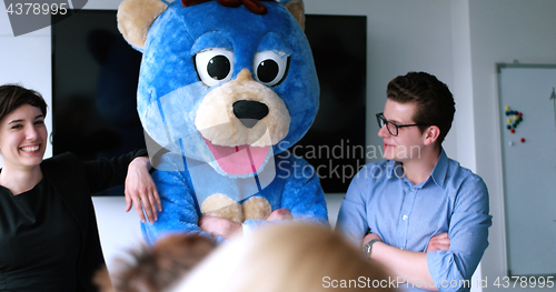 Image of boss dresed as bear having fun with business people in trendy of