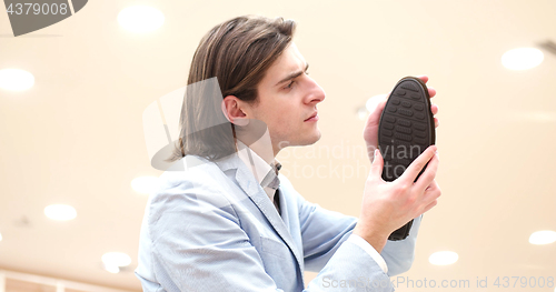 Image of Man Chooses Shoes At Shoe Store