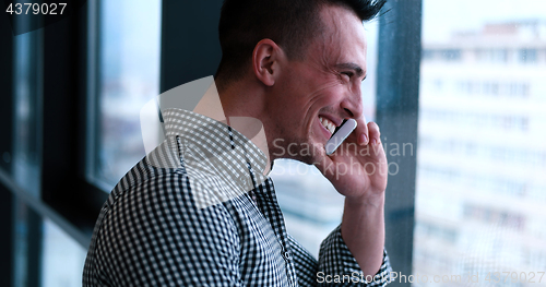 Image of Business Man Talking On Cell Phone, Looking Out Office Window