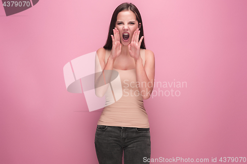 Image of Frustrated young woman screaming at studio