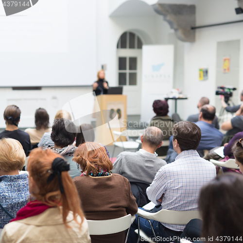 Image of Woman giving presentation in lecture hall at university.