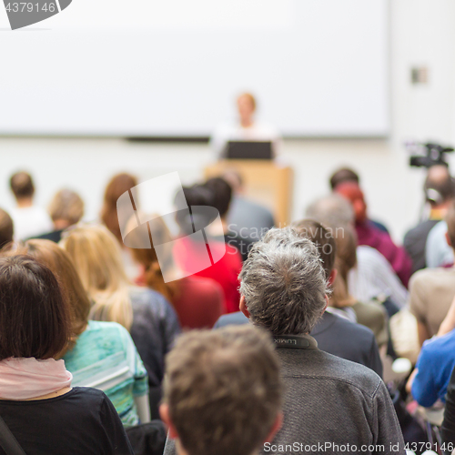 Image of Woman giving presentation in lecture hall at university.