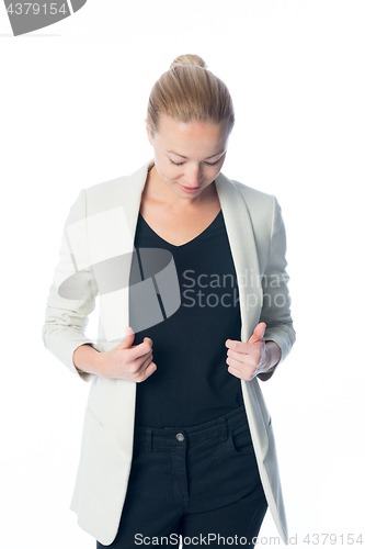 Image of Casual, relaxed, business woman looking down, standing against white background.