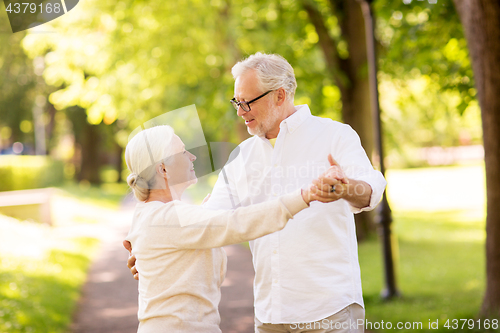 Image of happy senior couple dancing at summer park