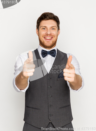 Image of happy man in festive suit pointing in camera