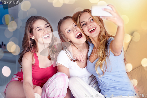 Image of teen girls with smartphone taking selfie at home