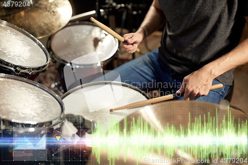 Image of male musician playing drum kit at concert