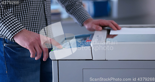 Image of Male Assistant Using Copy Machine in modern office