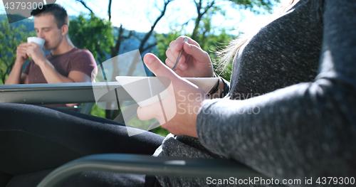 Image of Happy Couple Drinking Coffee and eating breakfast on terrace of 