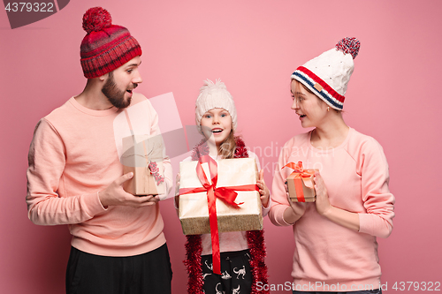 Image of Father and mother give gifts to little daughter at studio
