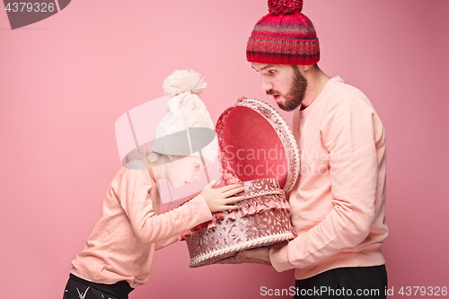 Image of Portrait of a surprised little girl with her father holding a Christmas present
