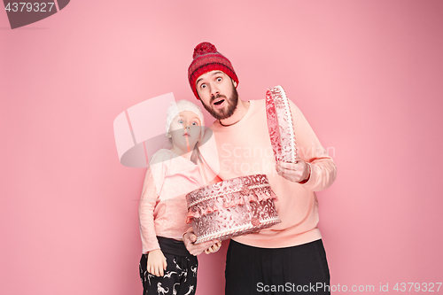Image of Portrait of a surprised little girl with her father holding a Christmas present