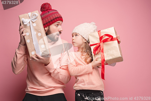 Image of Portrait of a surprised little girl with her father holding a Christmas present