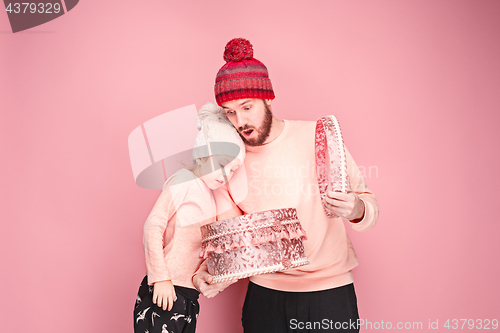 Image of Portrait of a surprised little girl with her father holding a Christmas present