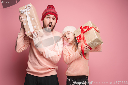 Image of Portrait of a surprised little girl with her father holding a Christmas present