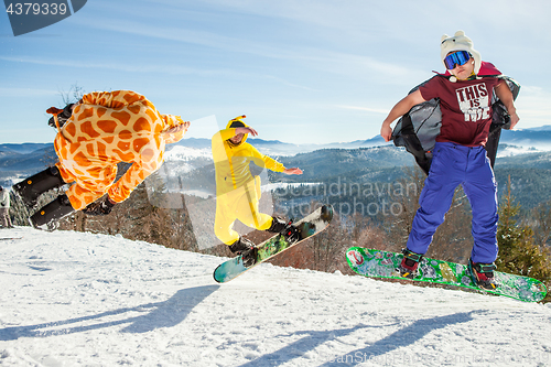 Image of Bukovel, Ukraine - December 22, 2016: Men boarders jumping on his snowboard against the backdrop of mountains, hills and forests in the distance. Bukovel, Carpathian mountains