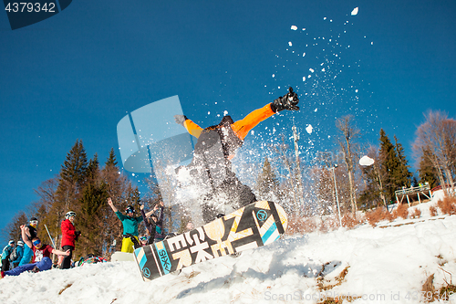 Image of Bukovel, Ukraine - December 22, 2016: Man boarder jumping on his snowboard against the backdrop of mountains, hills and forests in the distance. Bukovel, Carpathian mountains