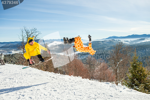 Image of Bukovel, Ukraine - December 22, 2016: Men boarders jumping on his snowboard against the backdrop of mountains, hills and forests in the distance. Bukovel, Carpathian mountains