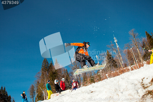 Image of Bukovel, Ukraine - December 22, 2016: Man boarder jumping on his snowboard against the backdrop of mountains, hills and forests in the distance. Bukovel, Carpathian mountains