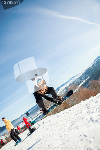 Image of Bukovel, Ukraine - December 22, 2016: Man boarder jumping on his snowboard against the backdrop of mountains, hills and forests in the distance. Bukovel, Carpathian mountains