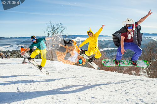 Image of Bukovel, Ukraine - December 22, 2016: Men boarders jumping on his snowboard against the backdrop of mountains, hills and forests in the distance. Bukovel, Carpathian mountains