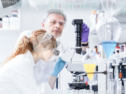 Image of Health care researchers microscoping in scientific laboratory.