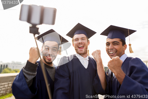 Image of happy male students or graduates taking selfie