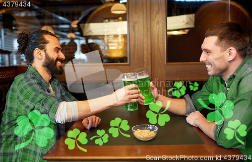 Image of male friends drinking green beer at bar or pub