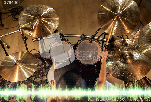 Image of male musician playing drum kit at studio 