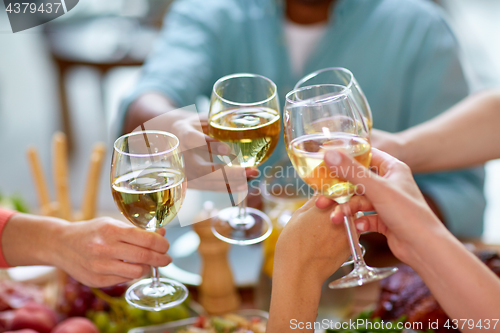 Image of hands clinking wine glasses