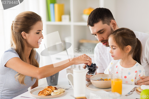 Image of happy family having breakfast at home