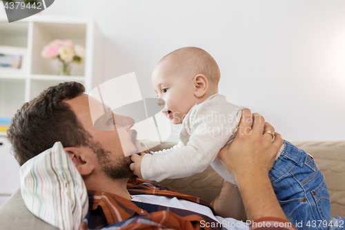 Image of happy father with little baby boy at home