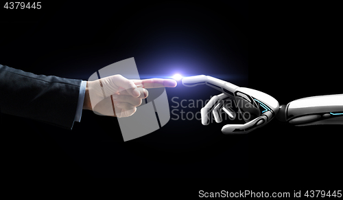 Image of robot and human hand flash light over black