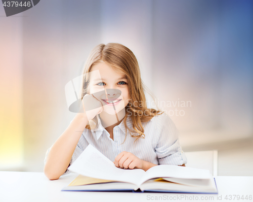 Image of happy smiling student girl reading book