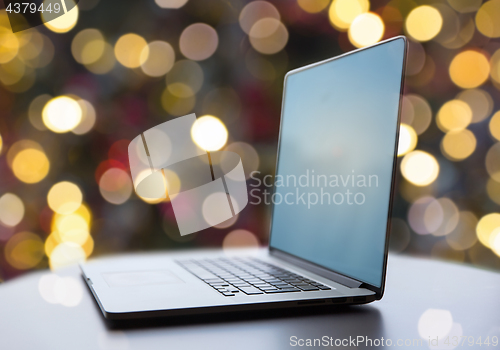 Image of laptop and coffee cup on table at christmas