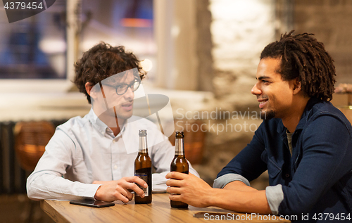 Image of happy male friends drinking beer at bar or pub