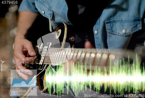 Image of close up of musician playing guitar at studio