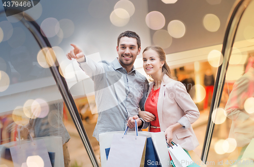 Image of happy young couple with shopping bags in mall