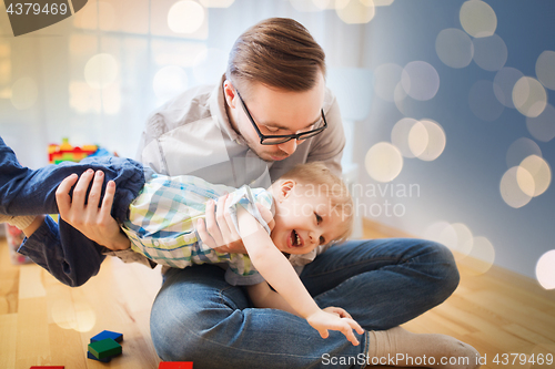 Image of father with son playing and having fun at home