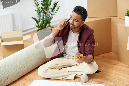 Image of man with blueprint and boxes moving to new home